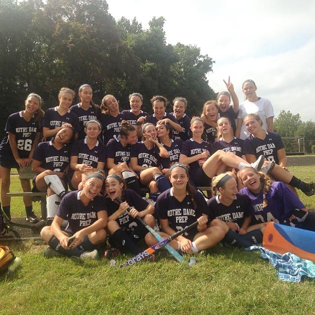 The field hockey team taking a silly picture after winning their game